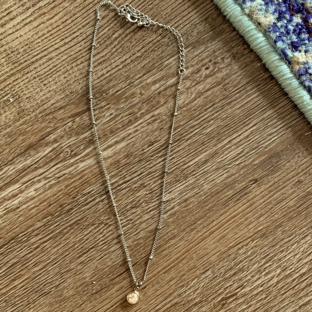silver necklace with small gold jewel